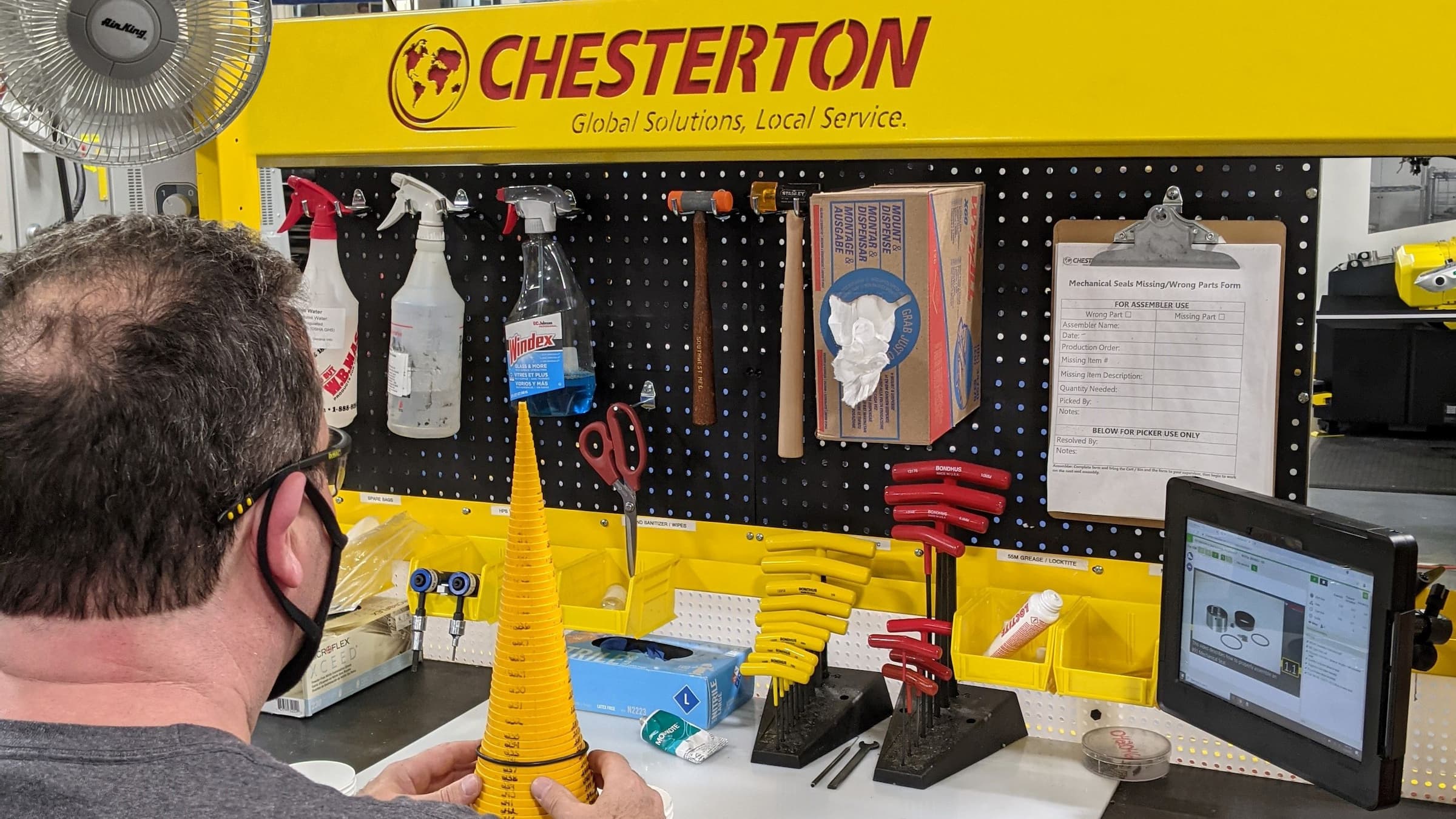 Worker sitting down at table with tools