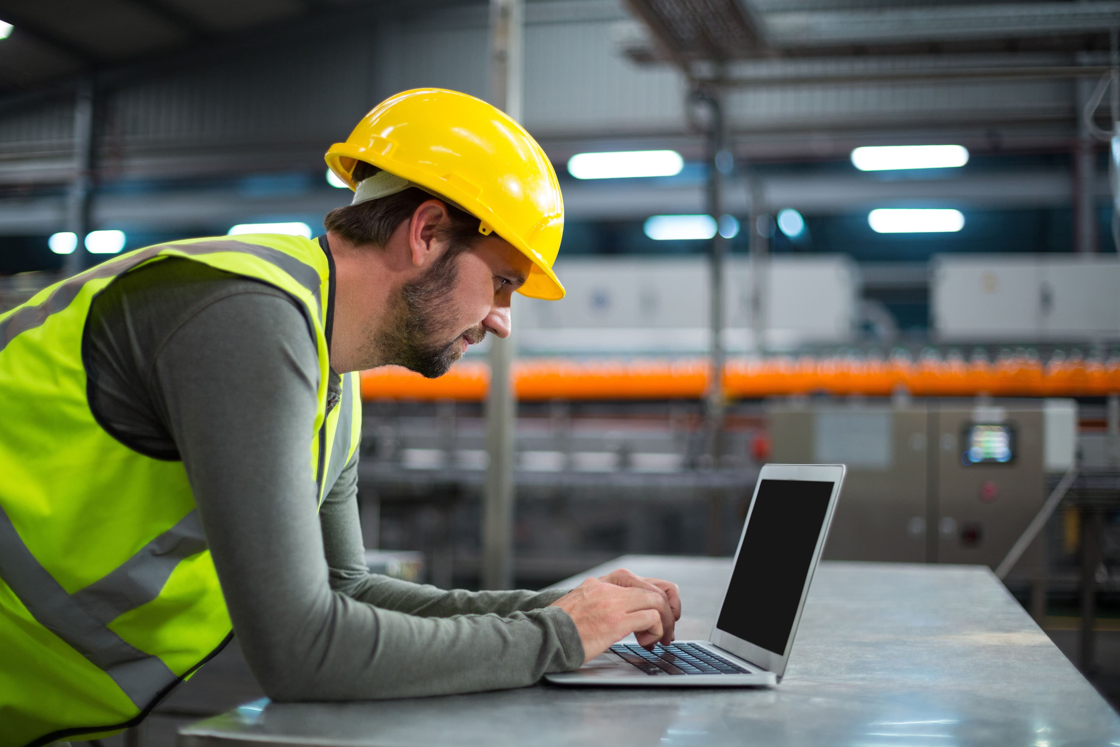 manufacturing worker looks at laptop