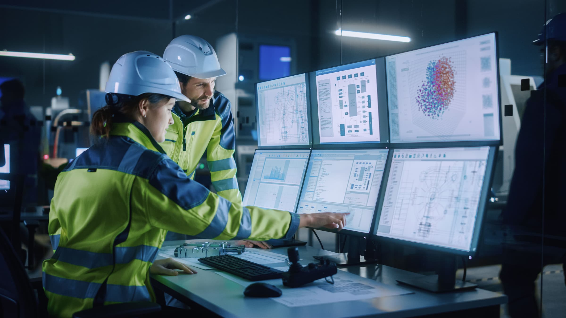 two workers assess automation vitals on computer screens