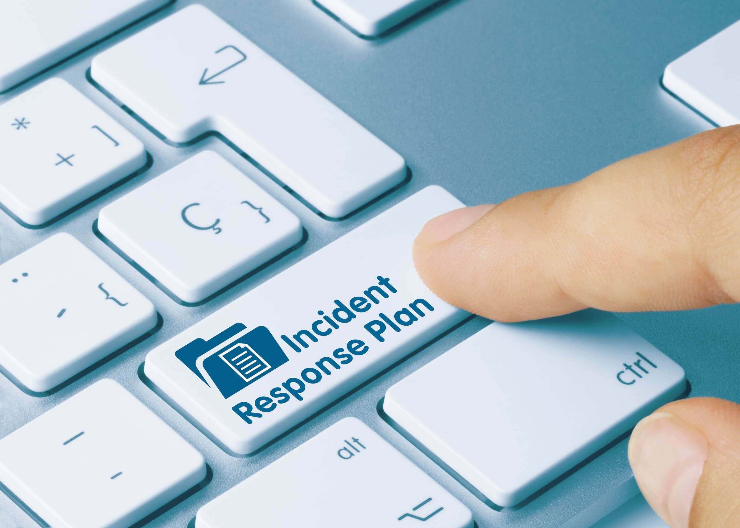 finger pressing enter key on keyboard labeled Incident Response Plan