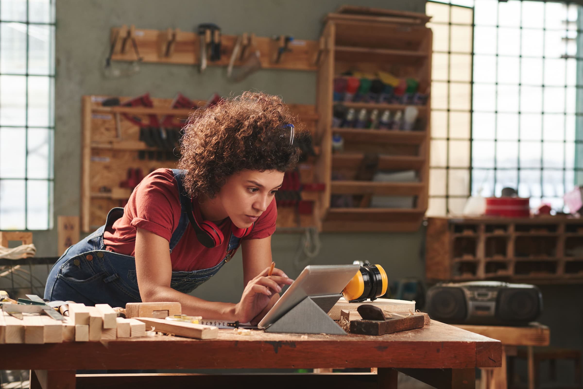 Woman reads digital work instructions in woodshop