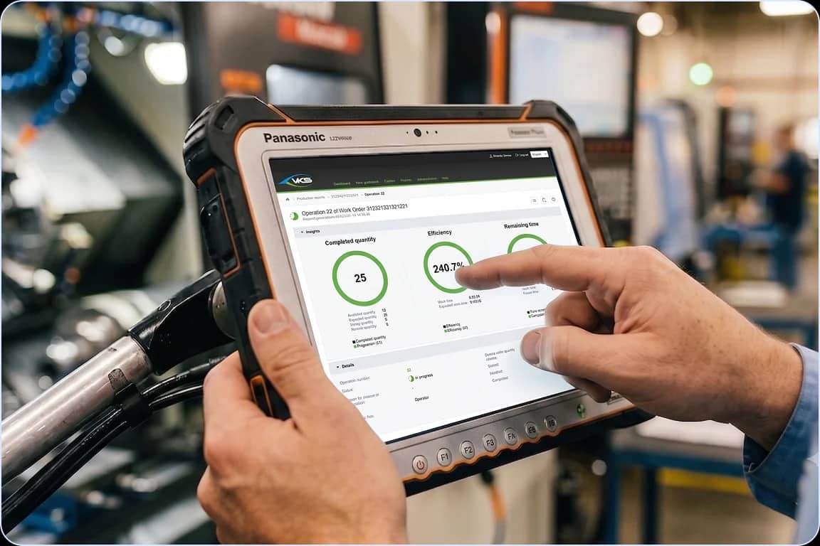 Operator holding a Panasonic rugged tablet displaying a VKS Pro KPI dashboard with efficiency gauges