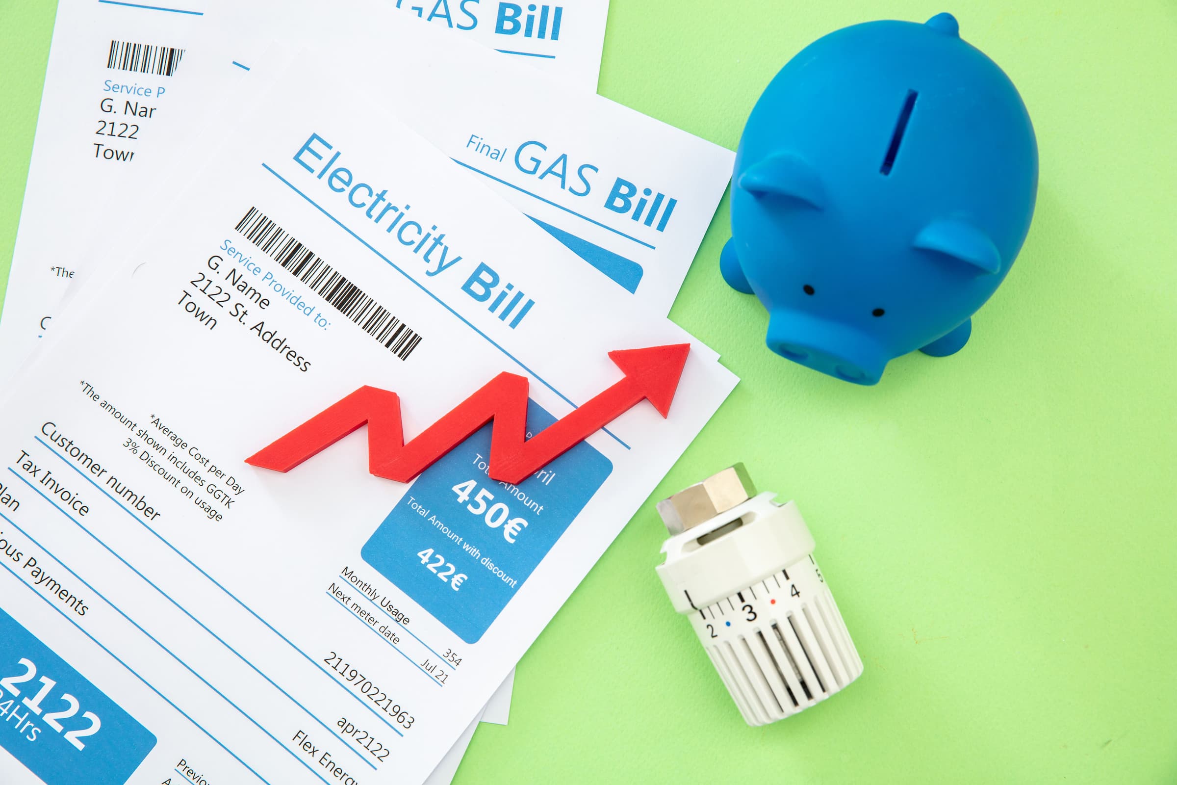 overhead costs as pile of utilities bills next to a piggy bank